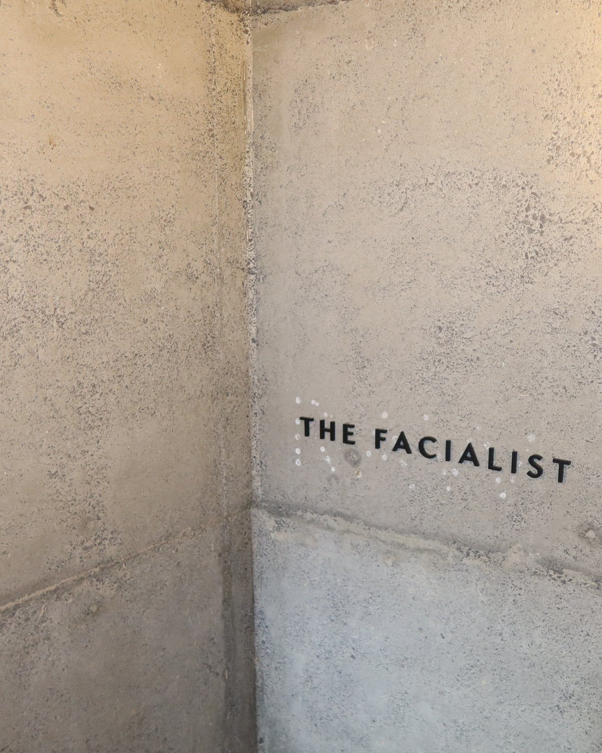 The Facialist sign on the concrete wall at City Works Depot